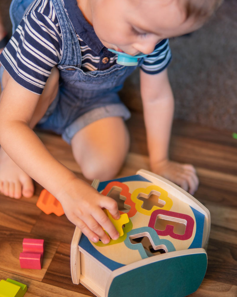 Child with sortino wooden toy by Selecta