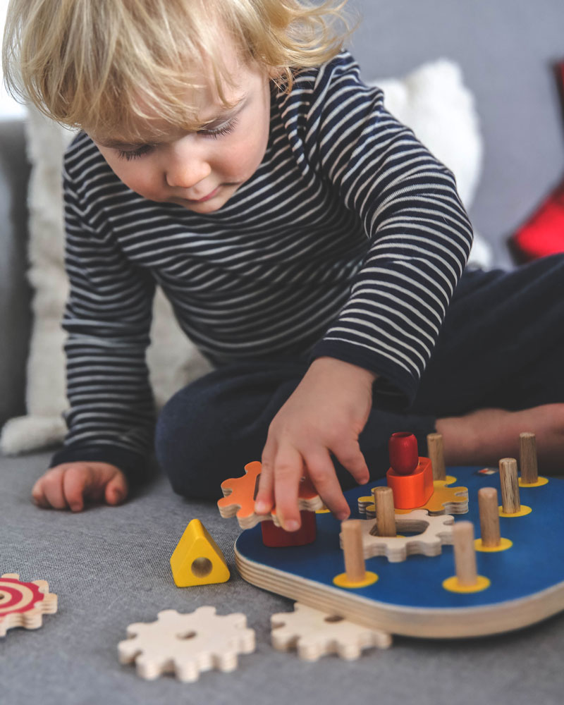Child with winding fun wooden toy by Selecta