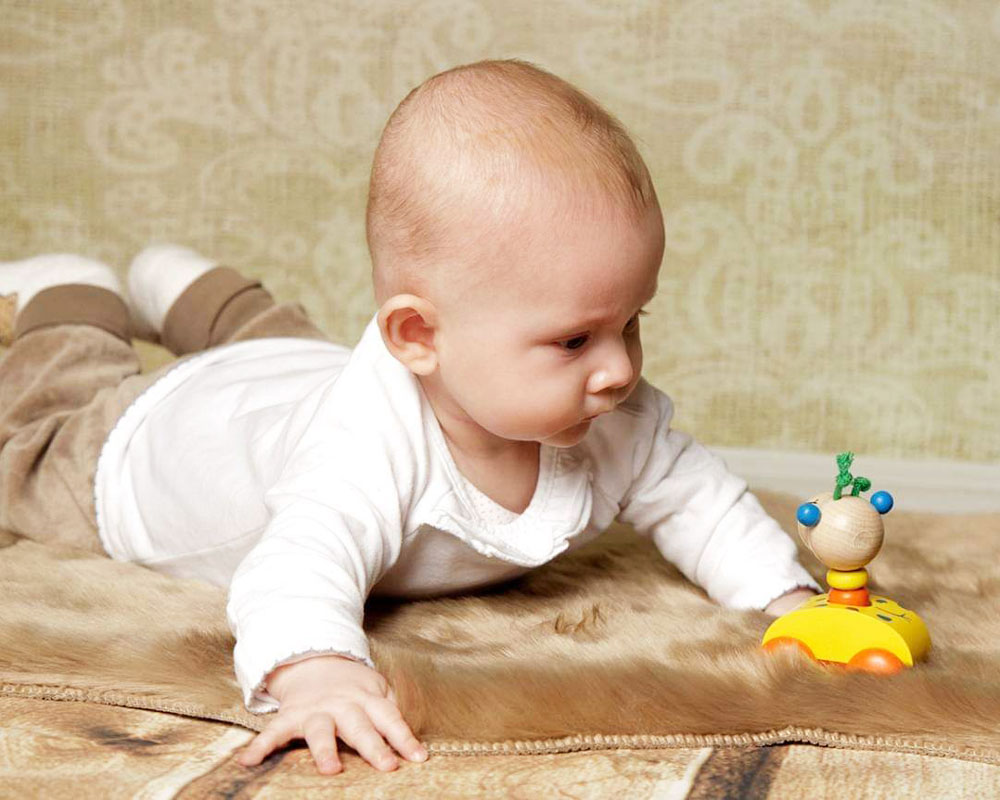 Baby with zoolini giraffe wooden toy by Selecta